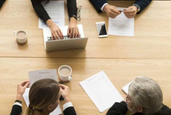 Genitori e avvocati al tavolo durante la definizione di un accordo di responsabilità genitoriale in Tribunale.