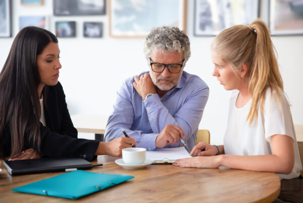 Coordinatore genitoriale incontra due genitori separati per discutere decisioni relative ai figli.