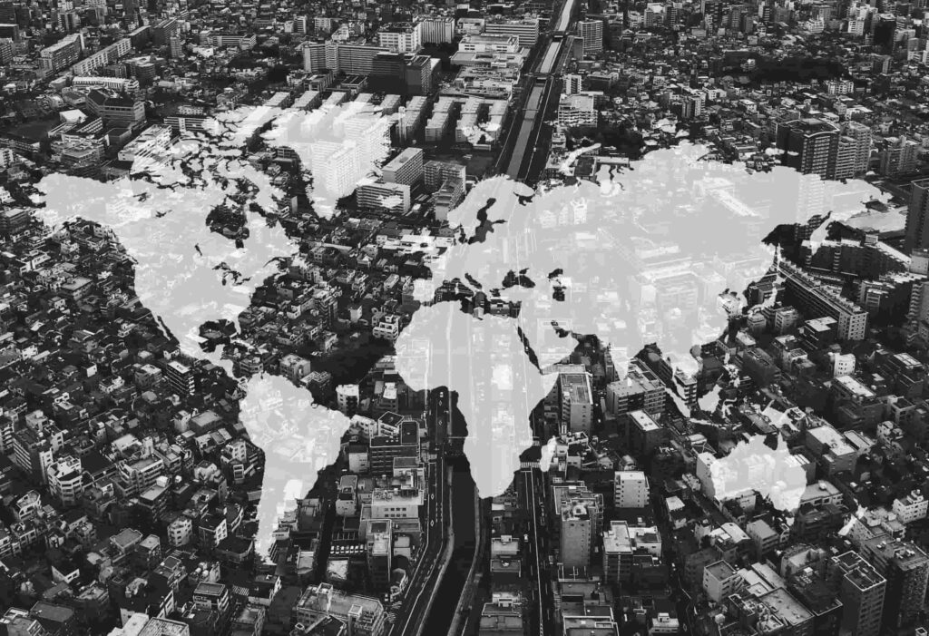 Mappa del mondo sovrapposta a una città che rappresenta la successione internazionale con beni ed eredi in più Paesi secondo il Regolamento UE 650/2012.